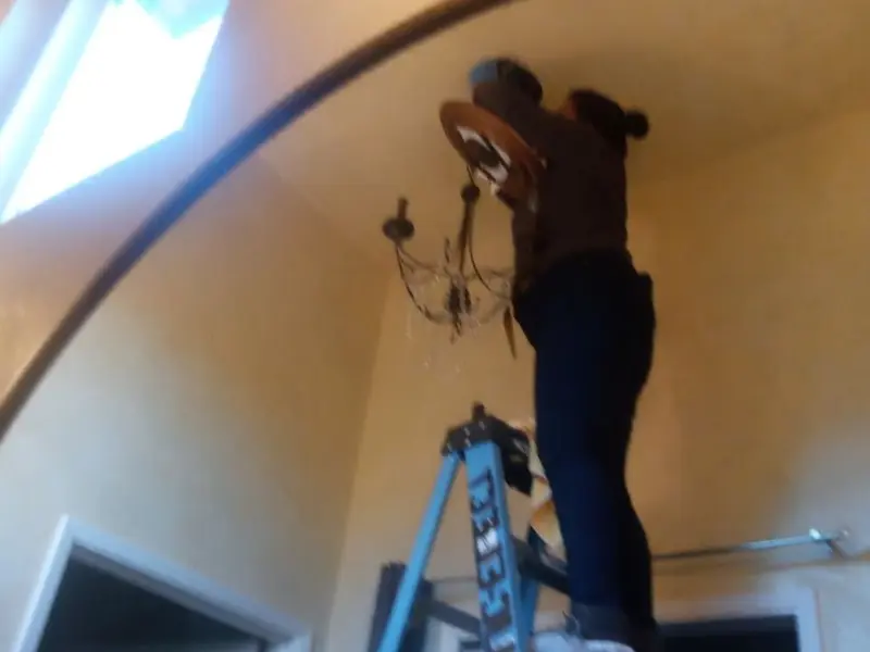 Electrician installing a chandelier in a Cudahy residence
